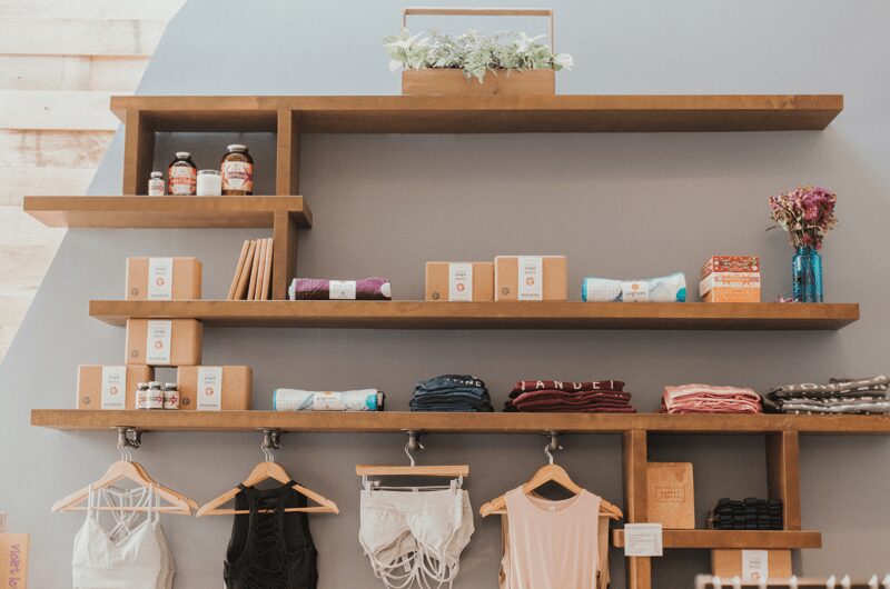 Clothing and products displayed on wooden shelves.