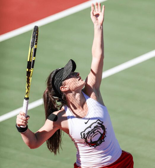 Tennis player preparing to serve on court.