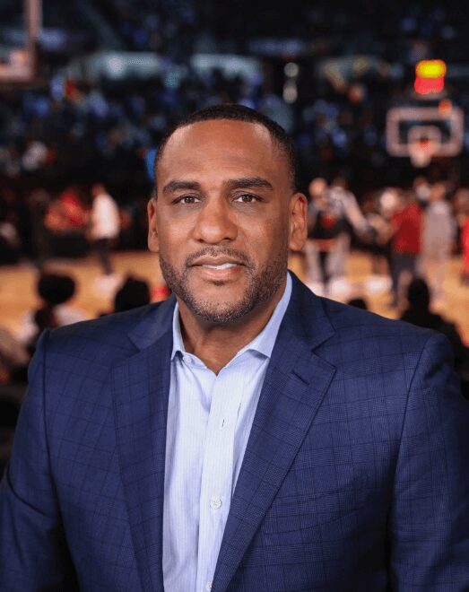 Man in blue suit at basketball game.