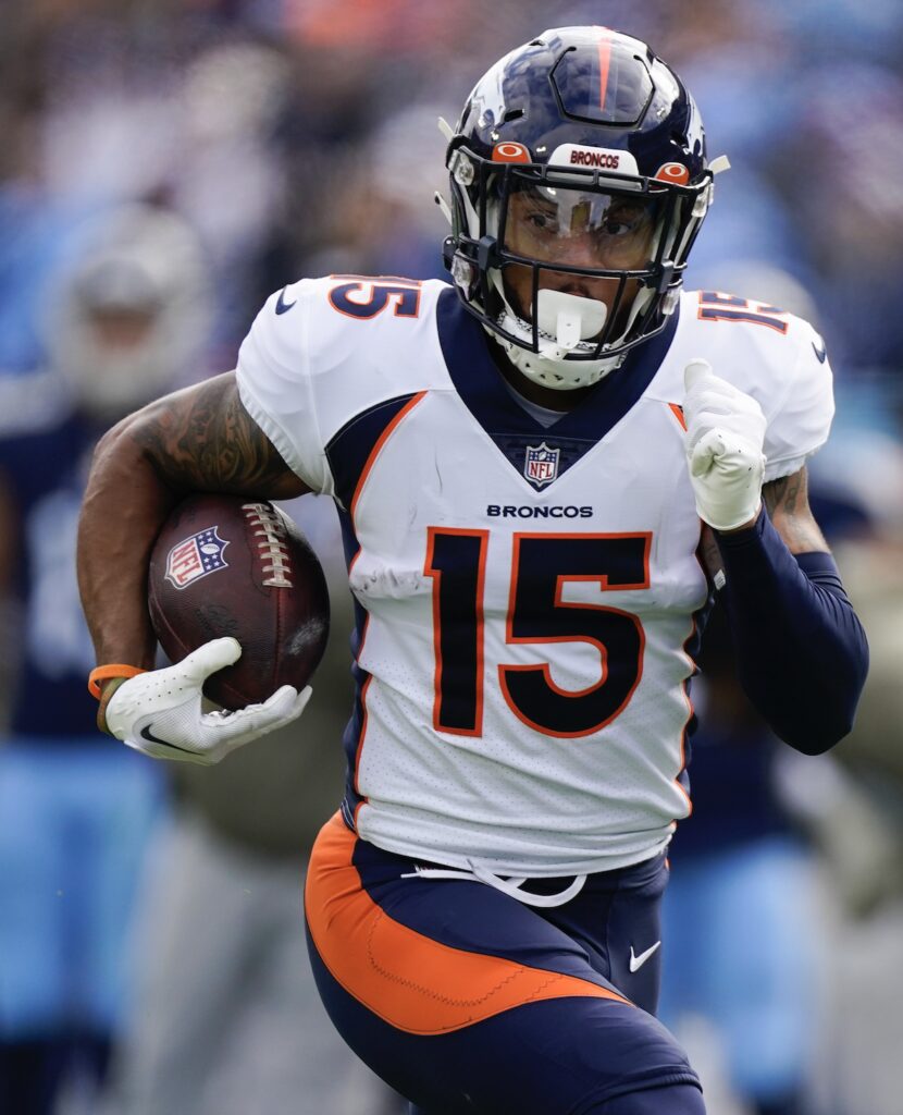 A football player running with the ball in his hands.