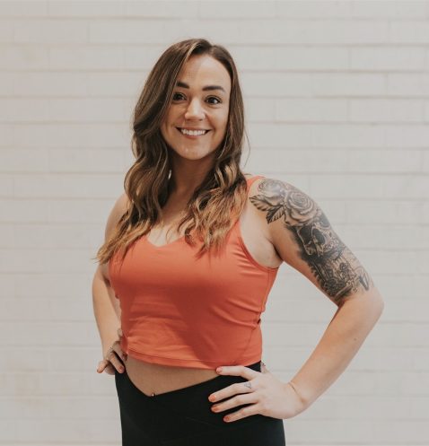 A woman standing in front of a white wall.