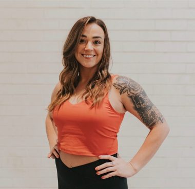 A woman standing in front of a white wall.