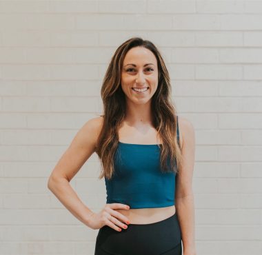 A woman standing in front of a white wall.
