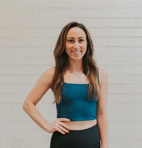 A woman standing in front of a white wall.