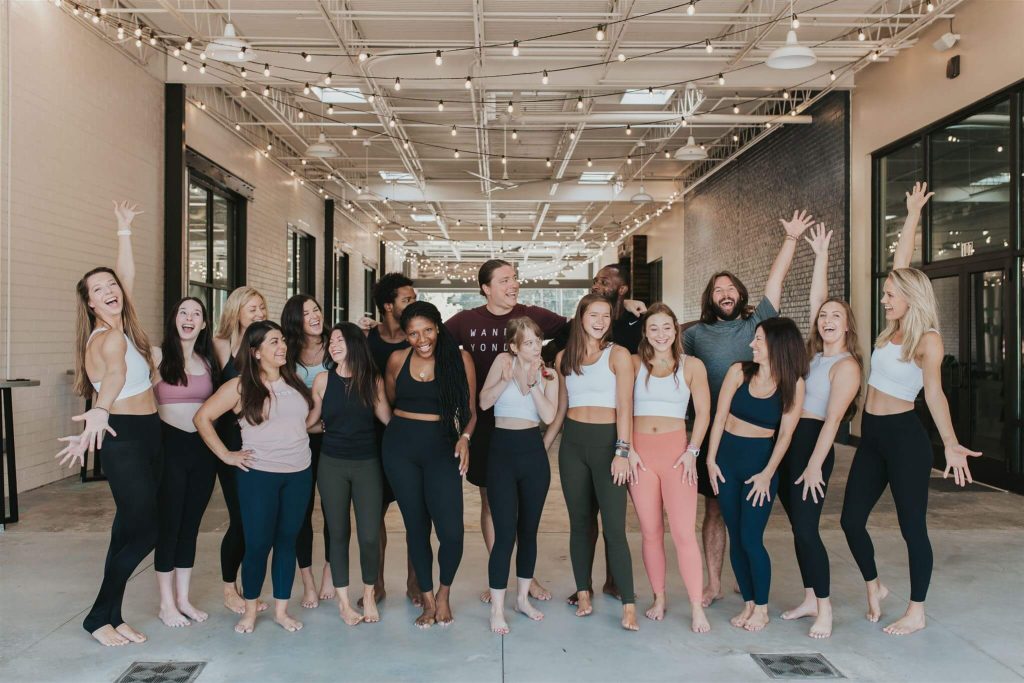 Group of people posing enthusiastically indoors.