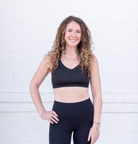 Smiling woman in black activewear outfit.