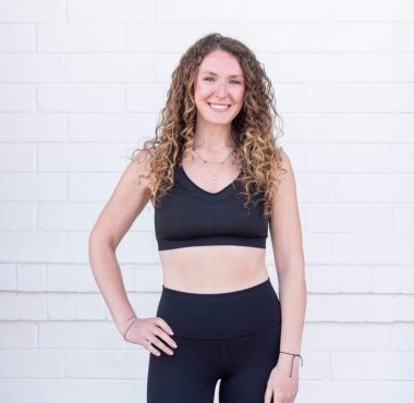 Smiling woman in black activewear outfit.