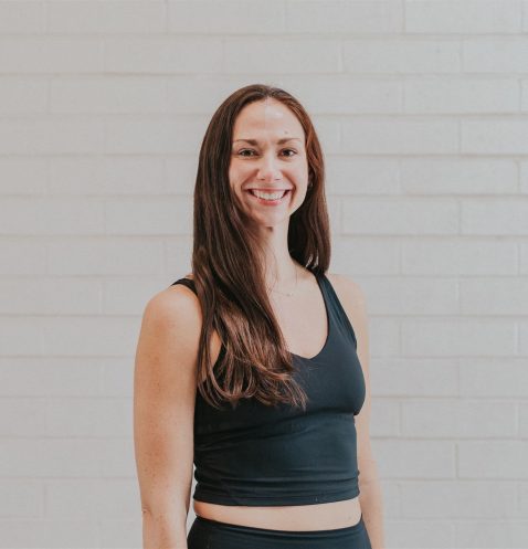 Smiling woman in black fitness attire.