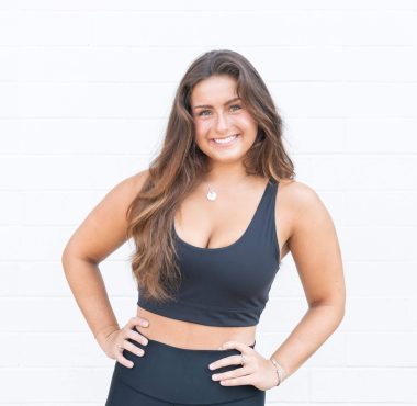 Woman in athletic wear smiling confidently.