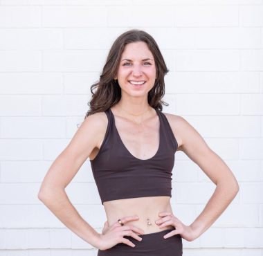 Woman smiling in black workout attire.
