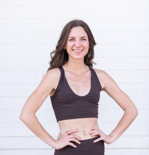 Woman smiling in black workout attire.