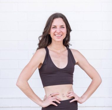 Woman smiling in black workout attire.
