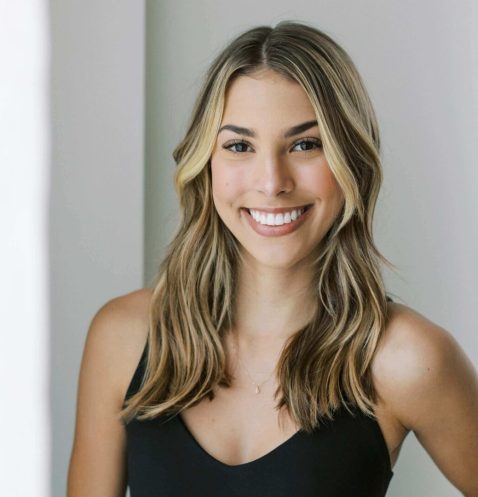 A woman with long hair smiles for the camera.
