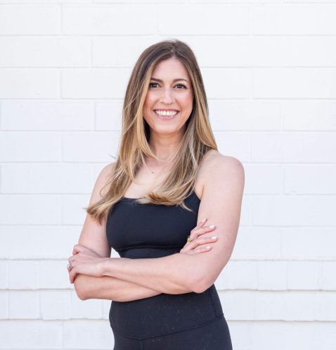 Smiling woman in black outfit, white background.
