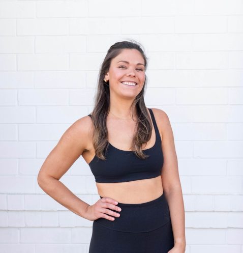 Smiling woman in black workout attire.