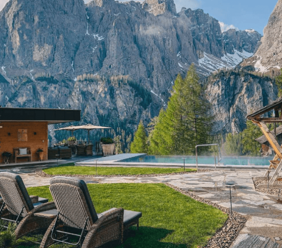 Mountain view with pool and lounge chairs.