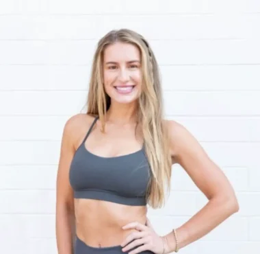 Blonde woman in gray sports bra smiling