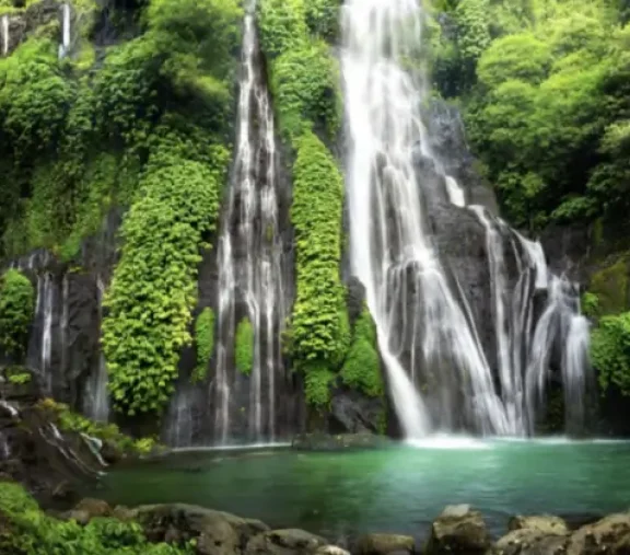 Twin waterfalls spilling into an emerald pool