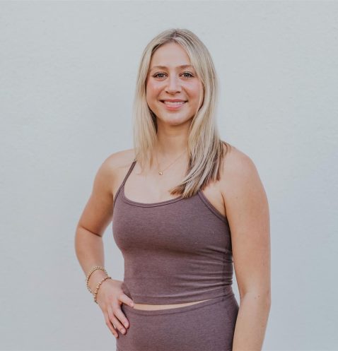 A woman standing in front of a white wall.