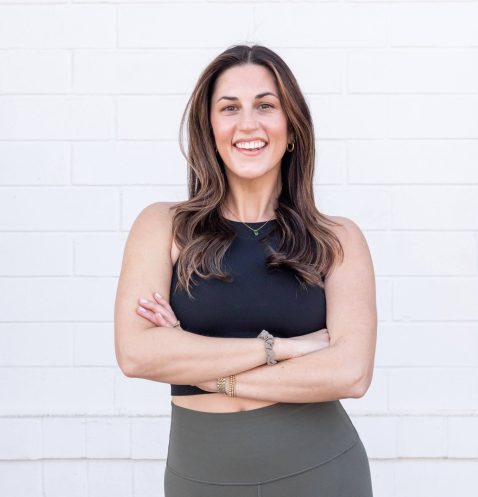 Smiling woman in black top, white background.