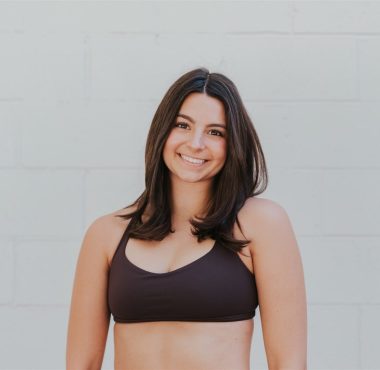 Smiling woman in black sports bra.