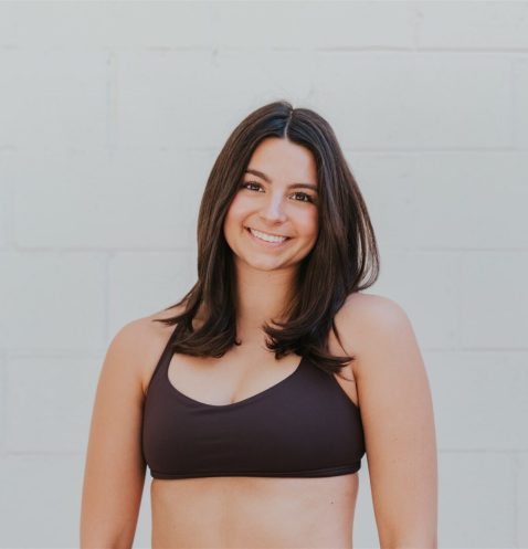 Smiling woman in black sports bra.