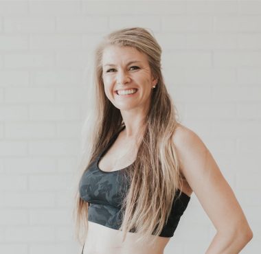 Smiling woman in black sports bra.