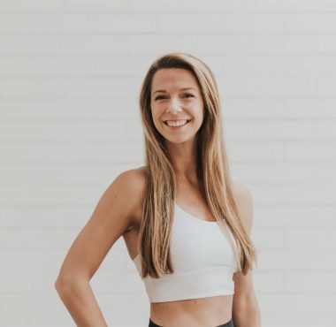 Smiling woman in a white sports top.