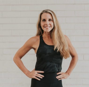 Smiling woman in black workout tank top.