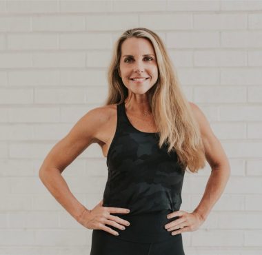 Smiling woman in black workout tank top.