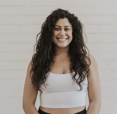 Smiling woman in white tank top.