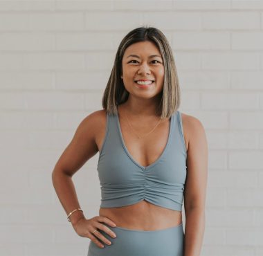 Woman smiling in gray workout outfit.