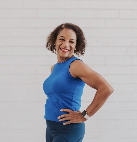 Smiling woman in blue workout outfit.