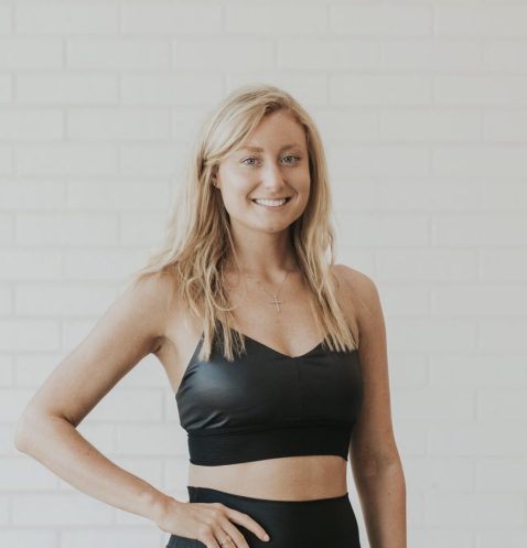 Smiling woman in black workout attire.