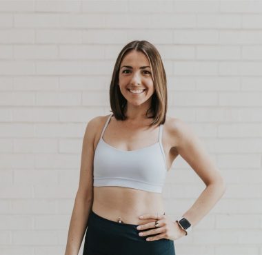 Smiling woman in workout attire indoors.