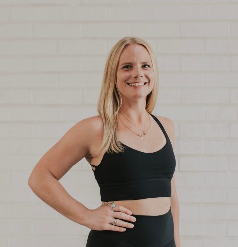 Smiling woman in black workout attire.