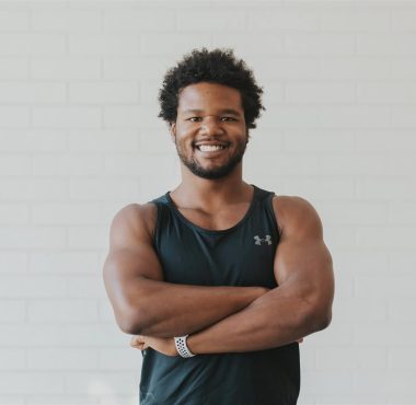 Man smiling in black tank top.
