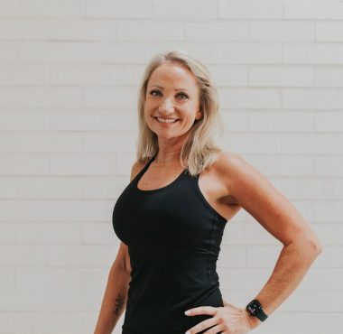 Smiling woman in black tank top.