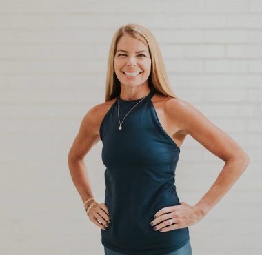 Smiling woman in athletic wear posing confidently.