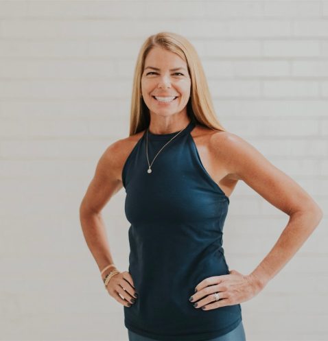 Smiling woman in athletic wear posing confidently.
