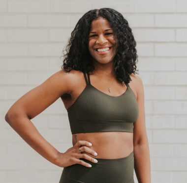Smiling woman in green athletic wear.