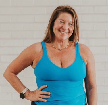 Smiling woman in blue tank top.