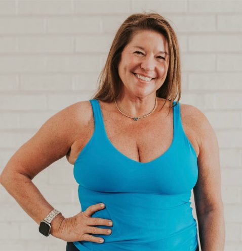 Smiling woman in blue tank top.
