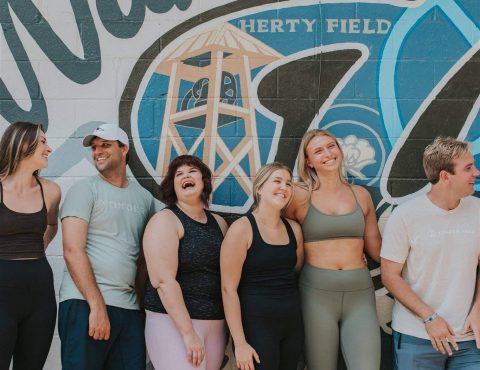 A group of people standing in front of a wall.