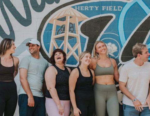 A group of people standing in front of a wall.