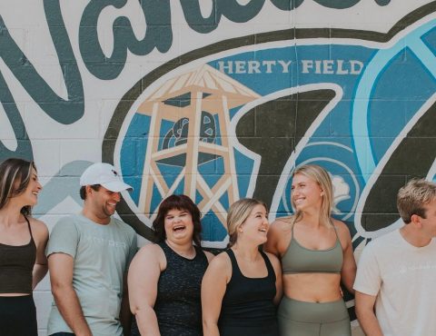A group of people standing in front of a wall.