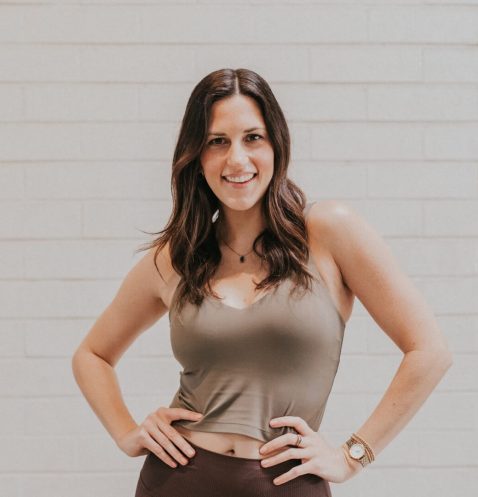 A woman standing in front of a white wall.