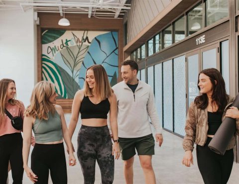 Group walking indoors with yoga mats.