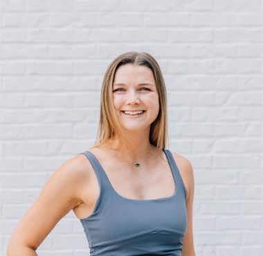 Smiling woman in gray athletic wear.