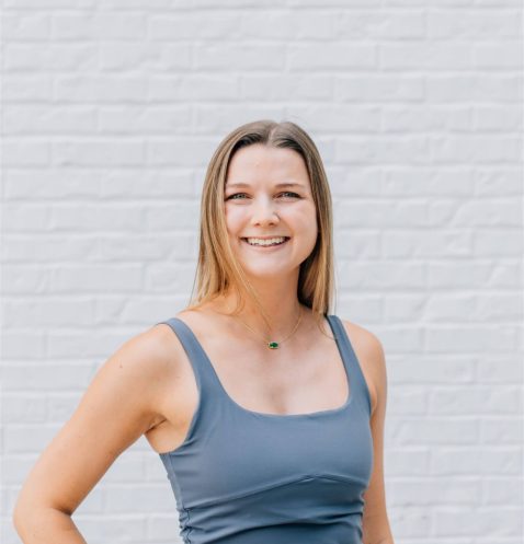 Smiling woman in gray athletic wear.